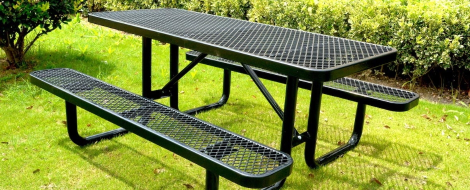 一个黑色钢板网做成的桌椅放在绿色草地上。