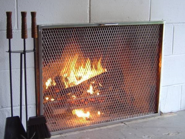 钢板网罩安装在壁炉的外面，壁炉里冒着火焰。