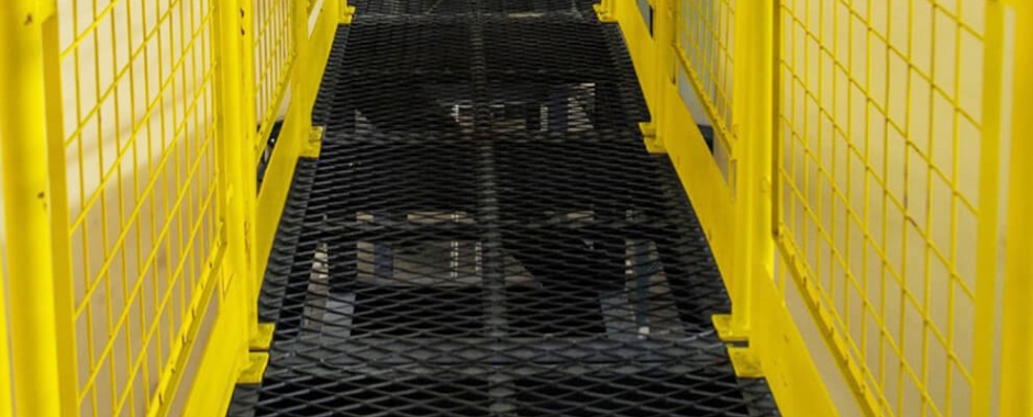 两边是黄色的围栏，中间是黑色钢板网通道。