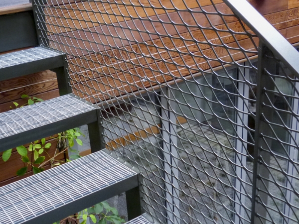 楼梯侧面栏杆采用的是压平型的钢板网填充板。