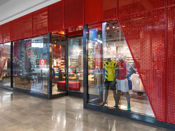 商场内服装店安装着红色的钢板网装饰墙。