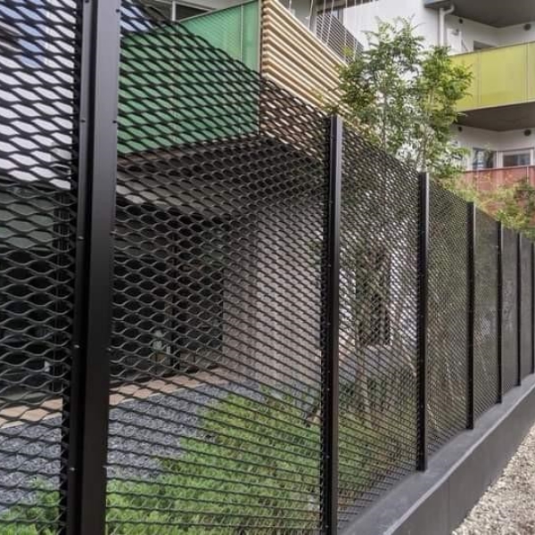 住宅楼外围安装着黑色的钢板网安全围栏。
