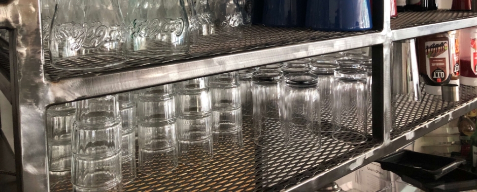 多个玻璃容器放到货架的钢板网隔板上。