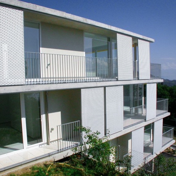 白色的钢板网遮阳板安装在住宅楼玻璃窗外面。